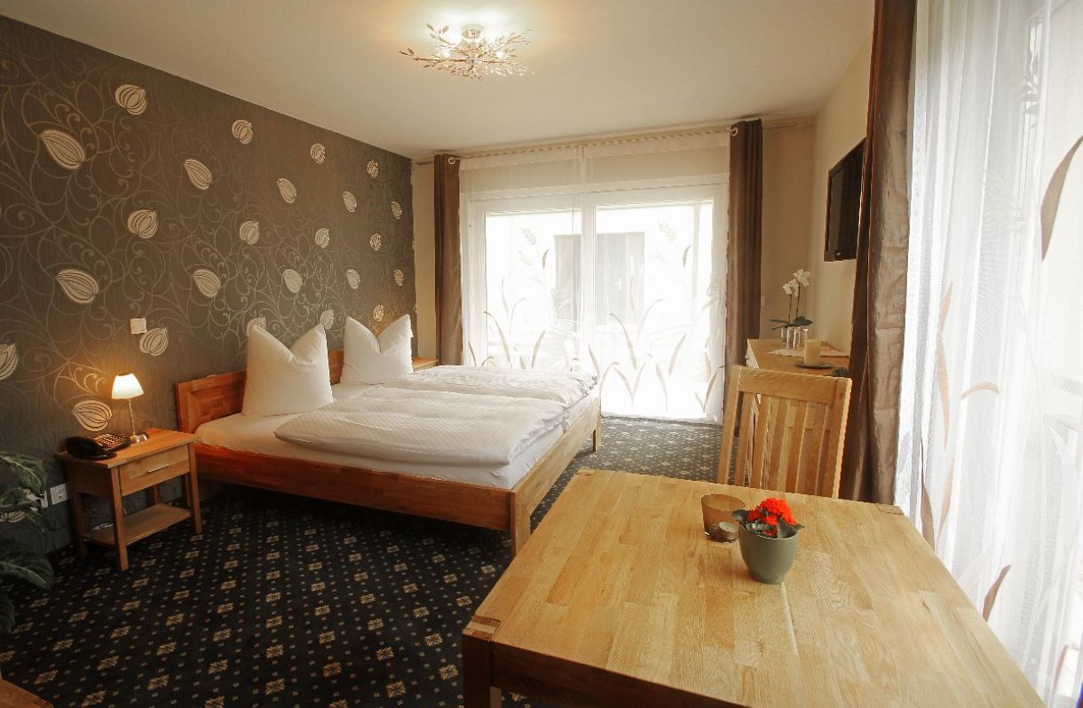 Haus 1: Doppelzimmer mit Tisch & Stuhl, Blick zum Fenster & Terrasse