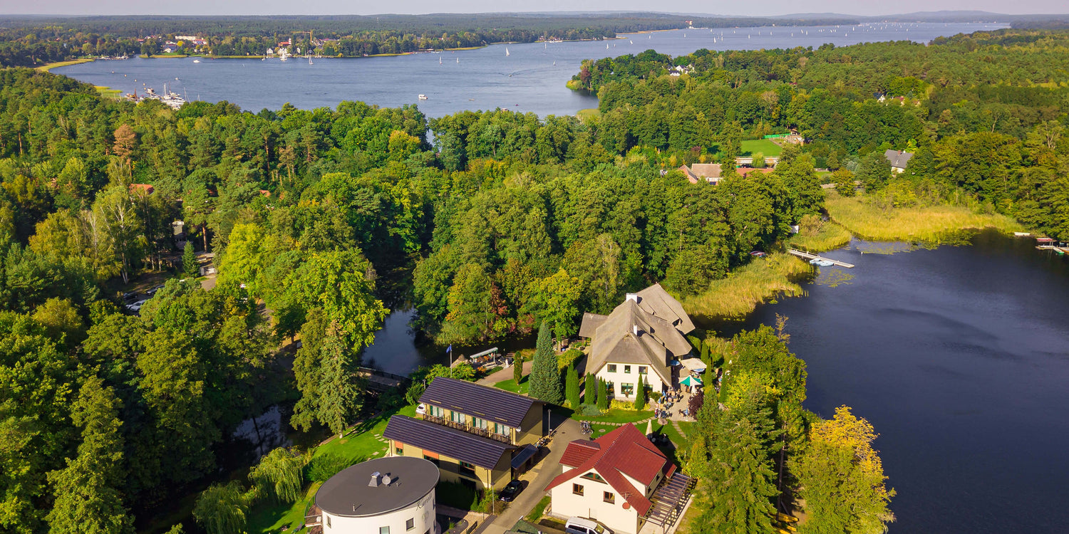 Bild von einer Drohne mit Blick auf das Fischhaus, Haus 1 und 2, dem Glubig-Melang Fließ, dem kleinen Glubigsee und hinten den Scharmützelsee
