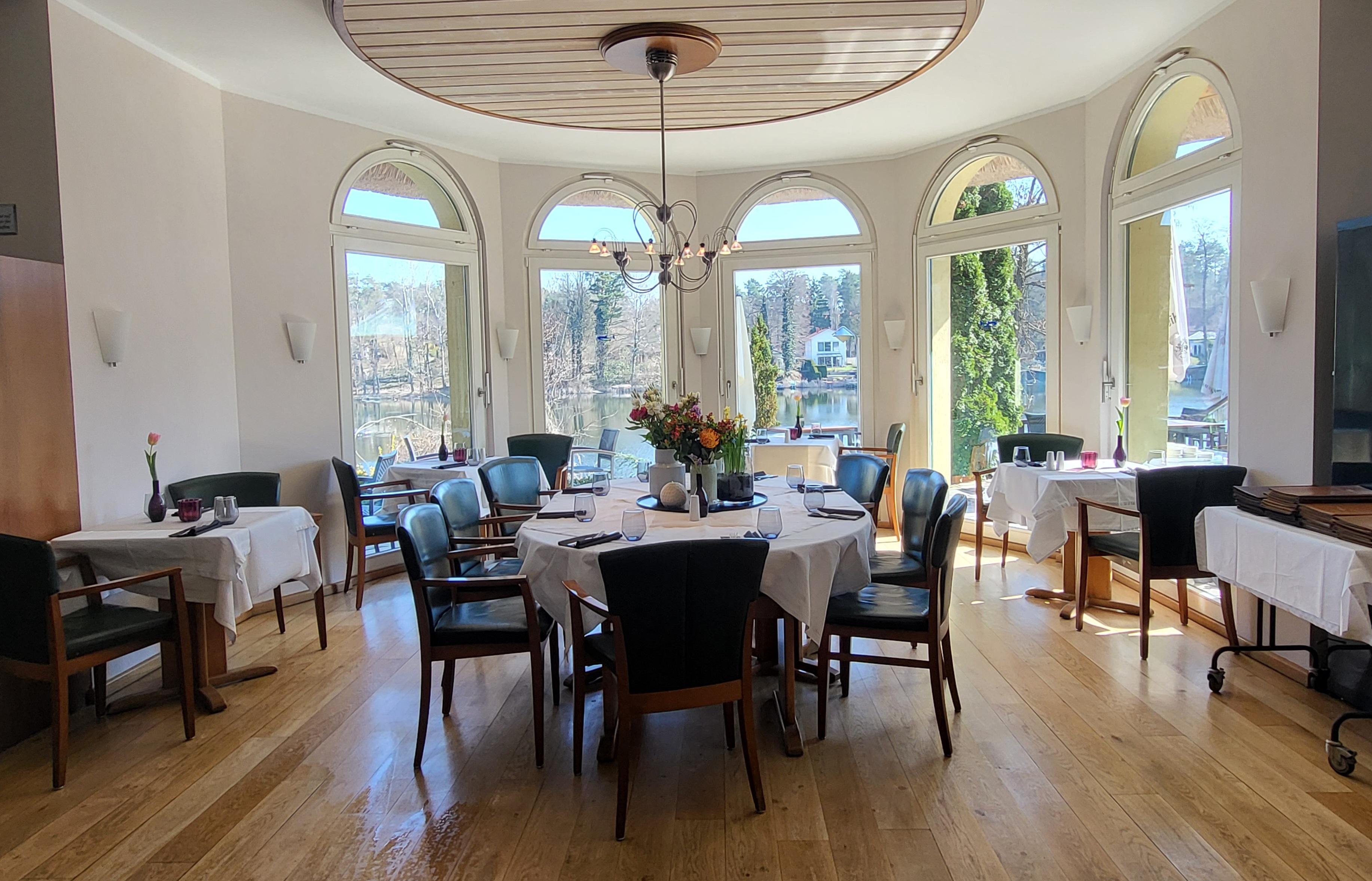 Restaurant Rondell mit zweier Tischen eingedeckt und einem großem Tisch für 8 Personen eingedeckt in der Mitte